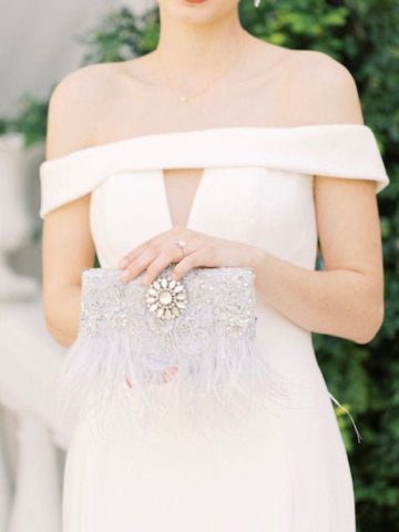 bride holding a feathered clutch