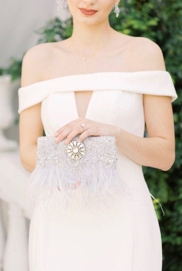 bride holding a feathered clutch