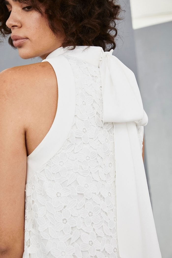 Bow tie detail on white lace mini dress