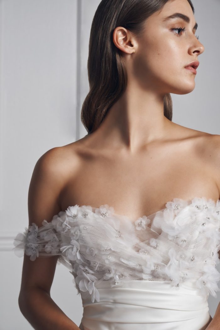 Detail of off-the-shoulder wedding dress with floral applique