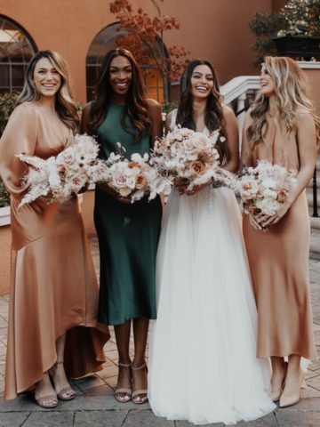 3 women in satin bridesmaid dresses in several colors and a bride