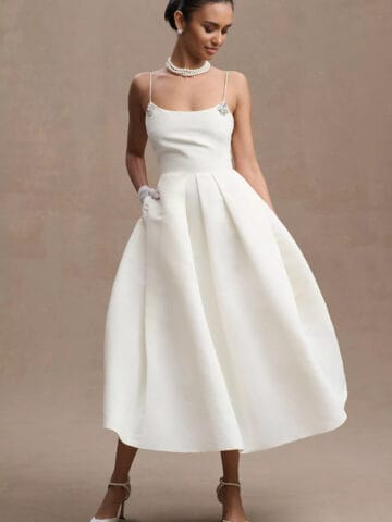 Model wearing a spaghetti strap short tea length wedding dress perfect for a simple wedding ceremony