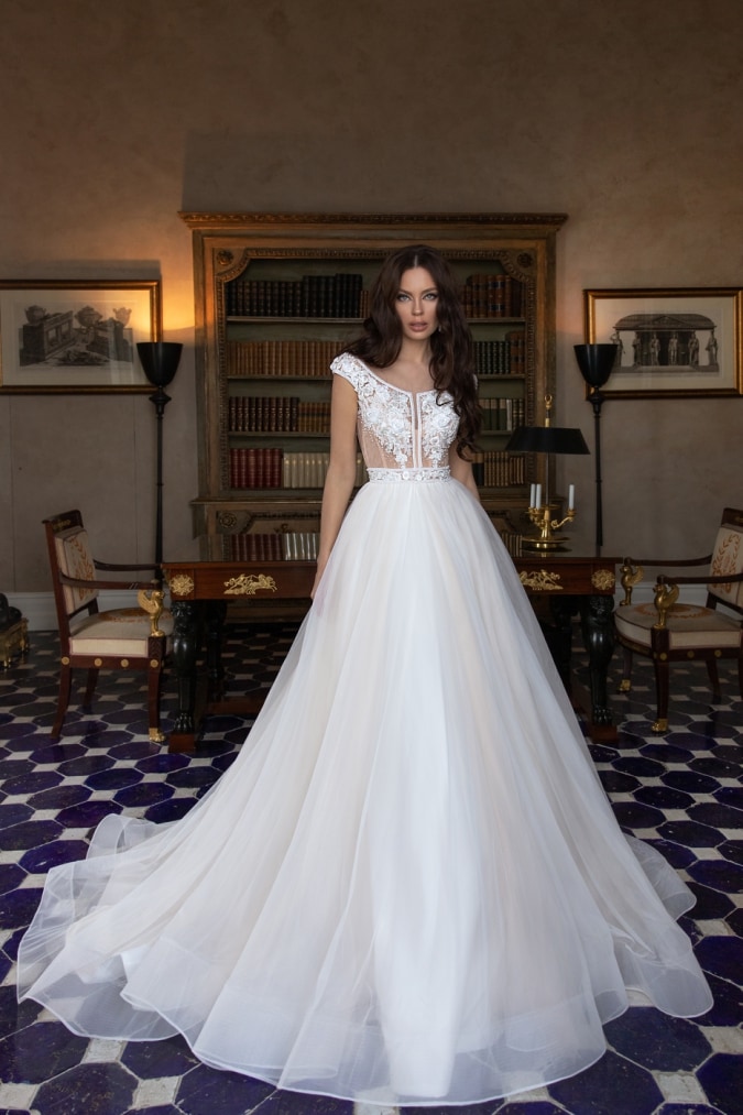 Cap sleeve lace top wedding dress worn by a model