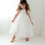 Young flower girl in a white dress