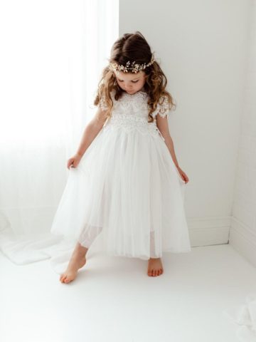 Young flower girl in a white dress