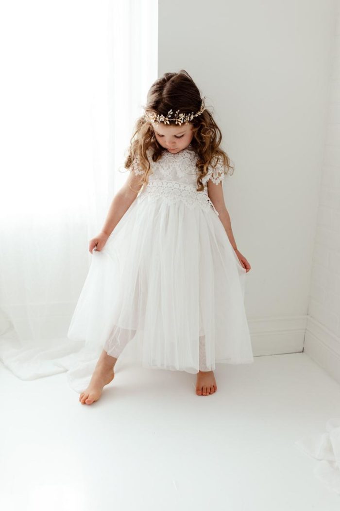 Young flower girl in a white dress