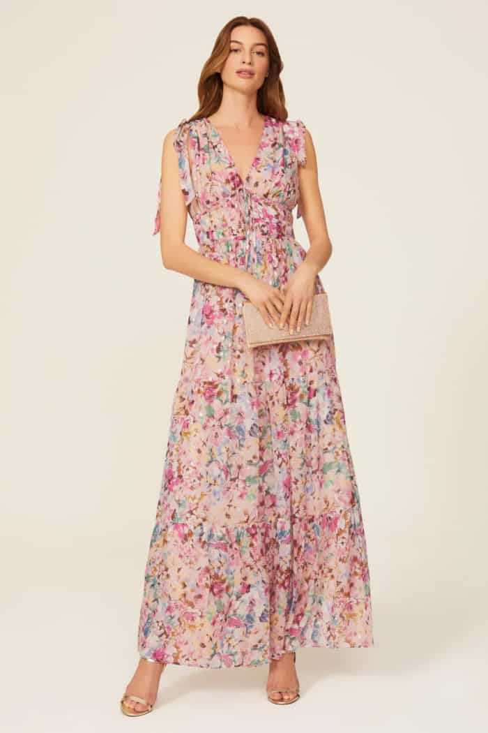 Long sleeveless small floral dress with pink background and multicolor flowers product shown on a model