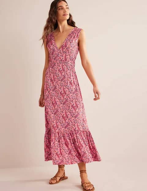 Sustainably made pink midi length summer dress with paisley pattern shown on a model 