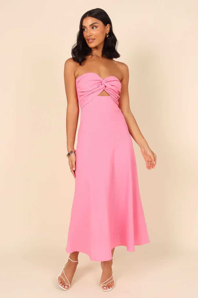 pink strapless midi dress with cutout at the midriff and about the ankle skirt shown on a model