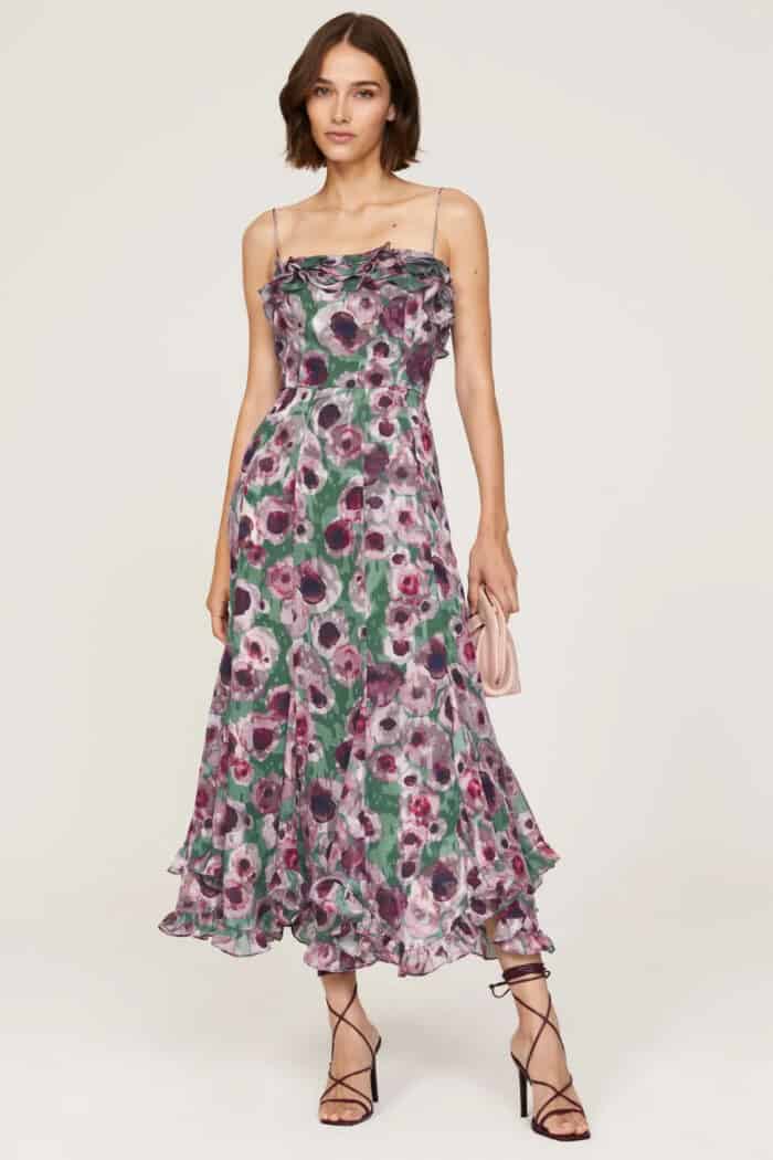 Floral dress with tones of purple and black with thin straps shown on a model
