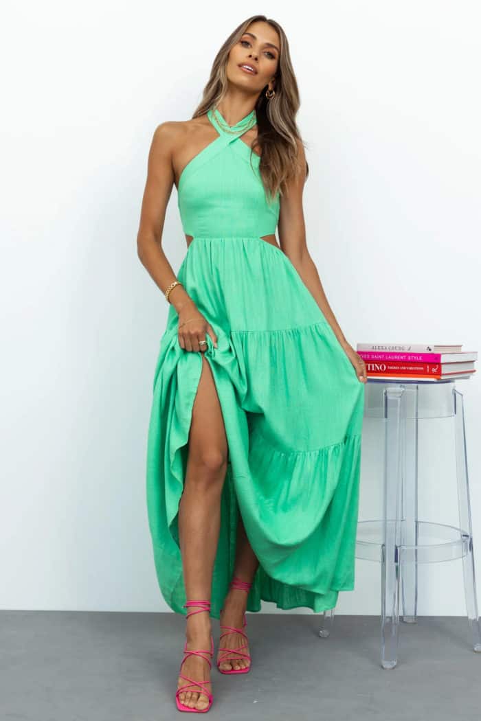 Bright green tiered maxi dress with halter style neckline and side cut outs shown on a model