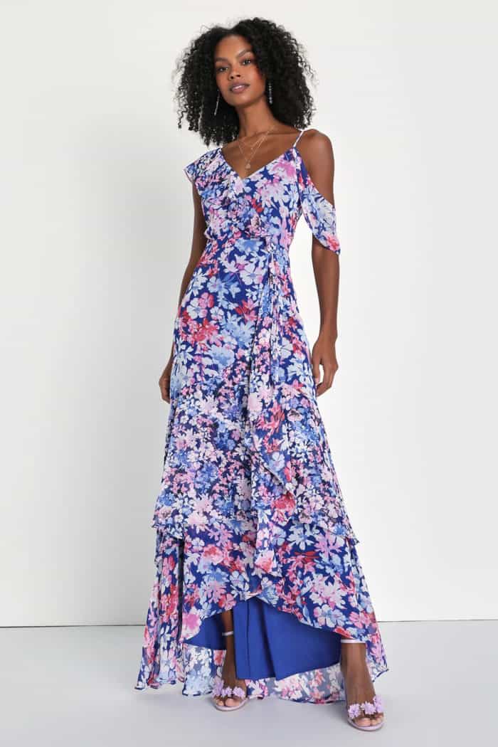 A navy blue floral maxi dress with asymmetrical neckline and hem shown on model