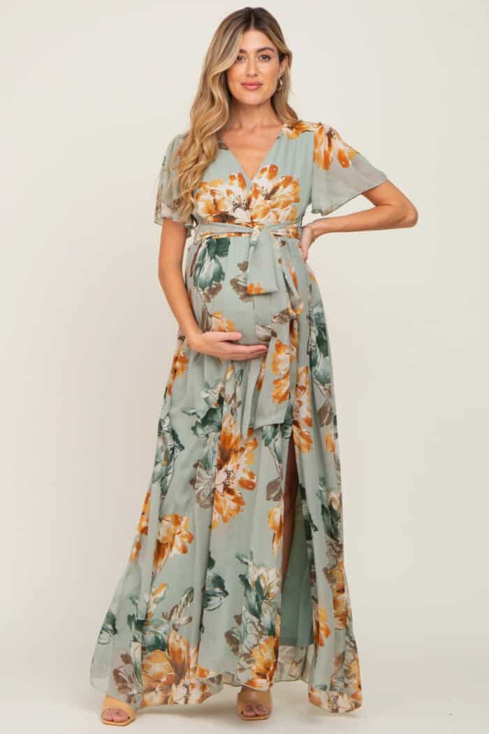 Model in a pale green floral short sleeve wrap maxi dress showing a pretty maternity dress to wear to a casual wedding or baby shower.