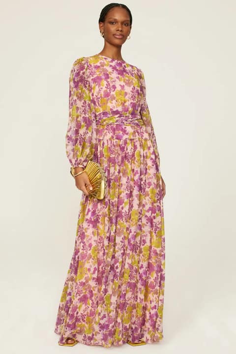 Model wearing a high neck long sleeve maxi dress with pink and gold flowers