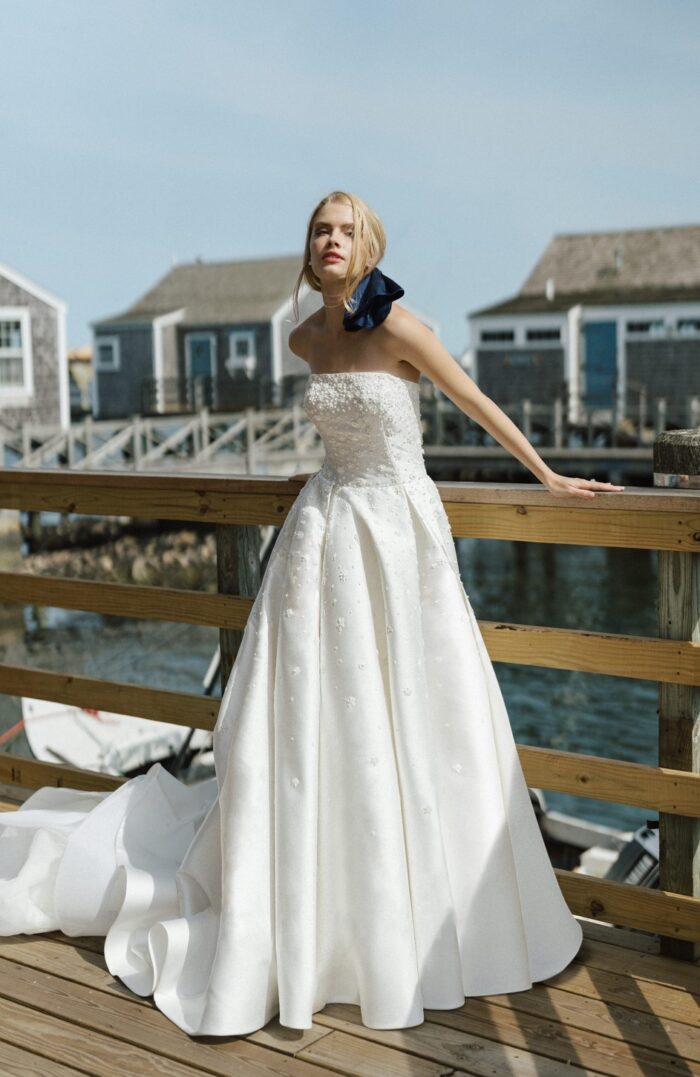 Model wearing strapless wedding dress in front of a dock walkway on Nantucket