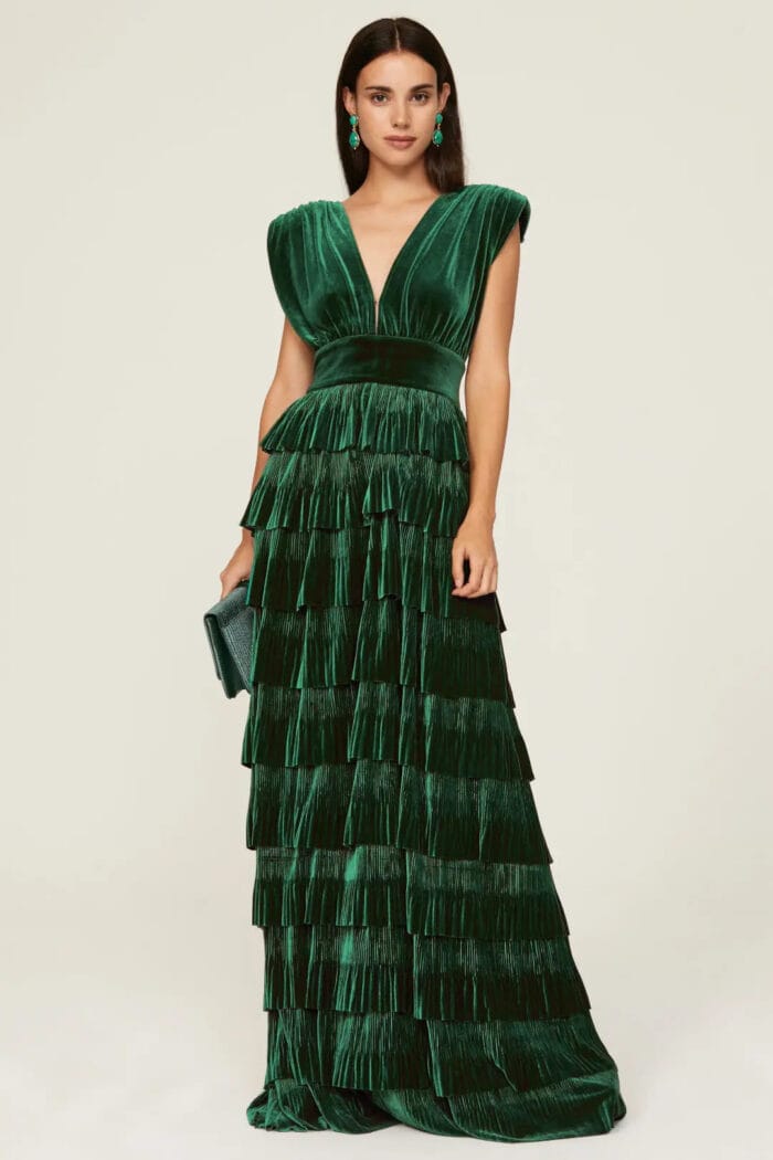 Emerald green velvet tiered dress on a model