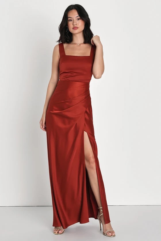 Model wearing a brick red satin gown with square neckline