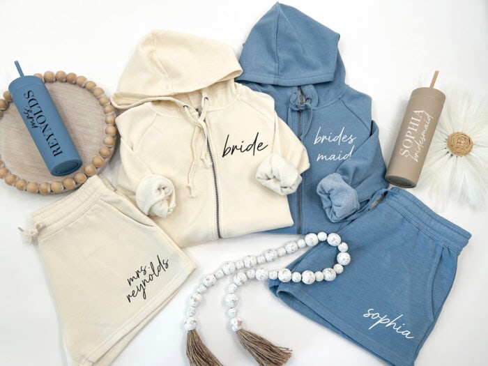 Flat lay picture of cream and blue hoodies and shorts with personalization