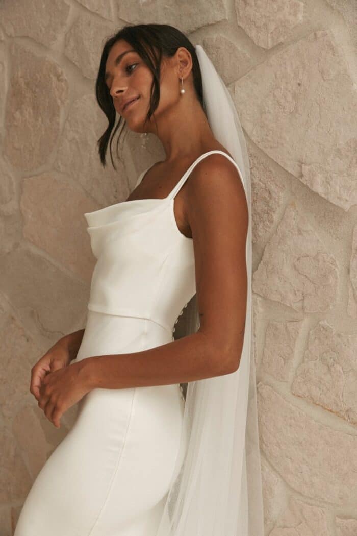 Detail view of model wearing a cowl neck wedding dress